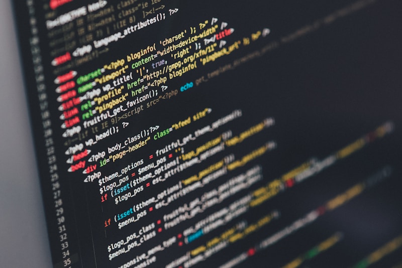 Software developer writing code on multiple monitors in a workspace